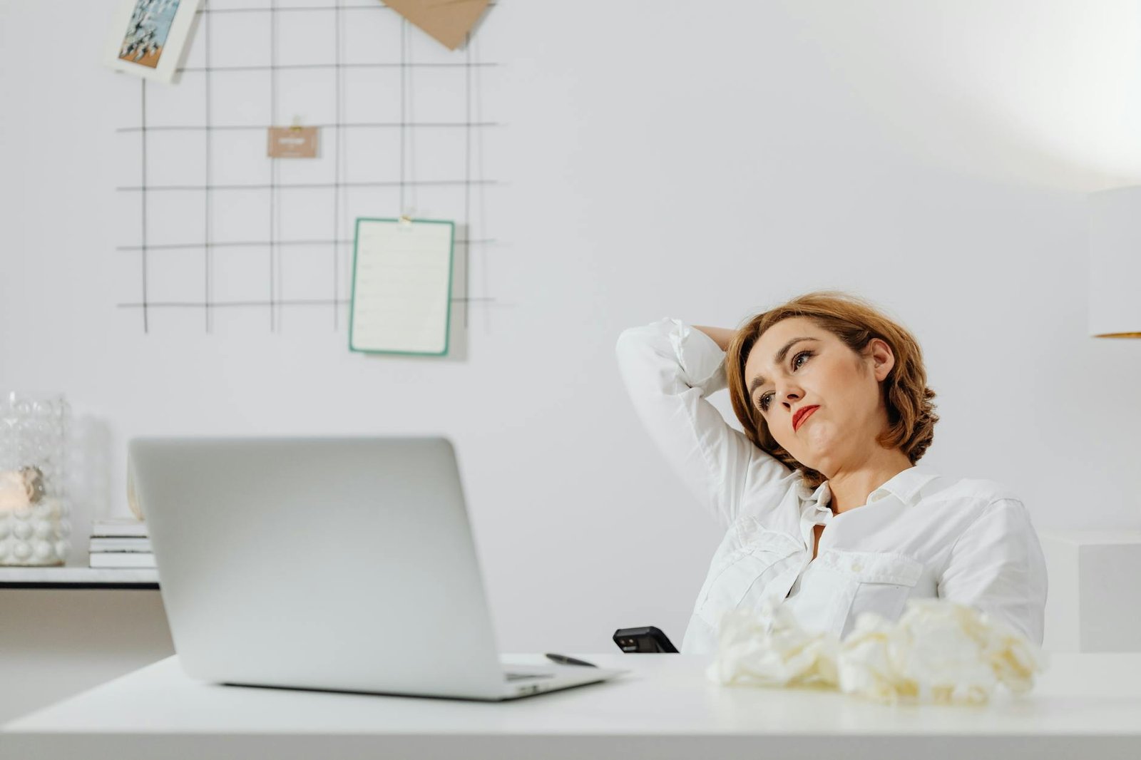 woman in white long sleeves shirt sitting in front of a laptop